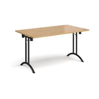 Rectangular folding leg table with black legs and curved foot rails 1400mm x 800mm - oak