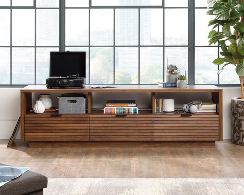 12900TK | The Teknik Office Hampstead Park TV Stand / Credenza is our stylish and minimalist design option for any home office or study. It features three smooth glide storage drawers with metal runners and safety stops and uniquely slatted fronts featuring metal handles. Above these drawers are three large cubbies / open shelves for even more versatile storage or display options for your media and hardware devices.  Finished in Grand Walnut effect finish, this can accommodate up to a 70 TV or media display device weighing up to 43kg.  There are also co-ordinating furniture items under the Hampstead Park Range that will complement this TV Stand/Credenza.