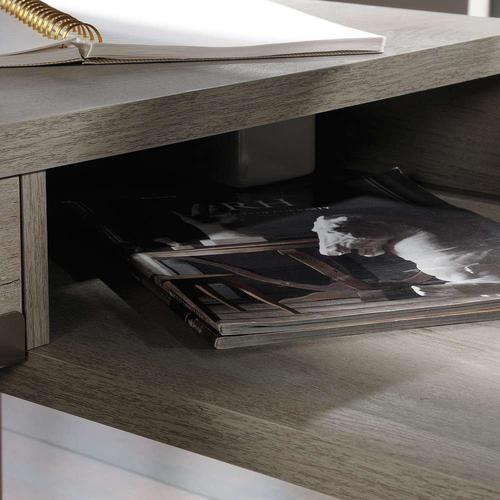 The Teknik Office Manhattan View L-Shaped Executive Desk is a sharp and minimalist design for those that need the full office solution for their home office without taking up all the room. It has a Mystic Oak effect finish desktop and shelves with a contrasting durable brown metal frame which is ideal for all styles and colour schemes. The large lightweight yet strong desktop and return provides a generous working area for all manner of study and essential office work. This L-shaped desk features an elevated shelf with cubbyhole storage which allows easy access to all of your office accessories. There is also a discreet stationery drawer with metal runners and safety stops for your convenience as well as a flip down panel for concealed storage located at the back of the desk. This item also has the added benefit of being finished 360 degrees for multiple placement within your room. Finally, you have a grommet hole which will aid you with cord management to keep everything nice and neat. All in all, a fabulous solution for all your home office needs.