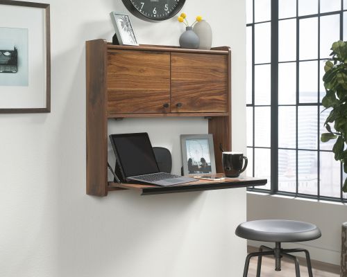12865TK | The Teknik Office Hampstead Park Wall Desk is our stylish and minimalist design option, perfect for all colour schemes and decor.  Beautifully finished in a Grand Walnut effect with black accents handles, this sleek and modern styled space saving wall desk provides a convenient solution for those with limited space, simple and versatile to hang anywhere within your home or office area. Separated with two distinct compartments, the lower half has a door which flips down to create a spacious work area for your laptop, work accessories and even your favourite cup of tea! The top half has two upper doors which open out to offer you even more storage for your office envelopes and folders; tacked on the inside of the doors is a bulletin style board for pinning your reminders and paperwork for when you need them.  On top of these is an upper shelf to complete the look, great for displaying all manner of home decor. This wall desk also includes cord management pass-throughs so you can keep all your wires neat and stowed away.  Also ideal to match in this range are the Narrow Bookcase, Wide Bookcase, Compact Desk and Park Desk, all finished in the same quintessential and modern style.