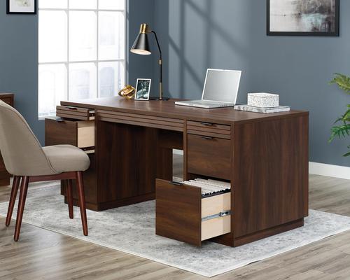 12823TK | The Teknik Office Elstree Executive Desk is an ideal option for those that need a stylish office solution for their home office.  This desk has a generous sized working surface finished in a stunning spiced mahogany effect which not only provides more than ample space for writing and computer work, it is an ideal match for all decorative interiors. There are two pencil drawers and two storage drawers with metal runners and safety stops to stash all manner of desking stationery as well as an additional two filing drawers that can hold letter or legal size hanging files. The left file drawer is lockable for secure storage.  There are also two grommet holes for discreet cable management. This desk also benefits being easy to assembled using the patented T-lock drawer system, it also has a 360 degree finish, for effortless and versatile placement anywhere within your home or office working area.