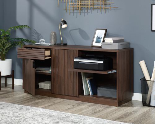 12760TK | The Teknik Office Elstree Credenza is an ideal option for those that need a stylish office solution for their home office.  With its louvre-style detailing and finished in a stunning spiced mahogany effect, you can be sure of an ideal match for all decorative interior and tastes. It has an adjustable shelf behind each door for flexible storage options and a generous top surface for additional display for your file tray, favourite plant or books. It also benefits from a pull-out adjustable printer shelf and storage drawer with metal runners and safety stops. This credenza has a patented T-lock drawer system which makes for a quick and easy assembly. It also has a 360 degree finish, for effortless and versatile placement anywhere within your home or office working area. 