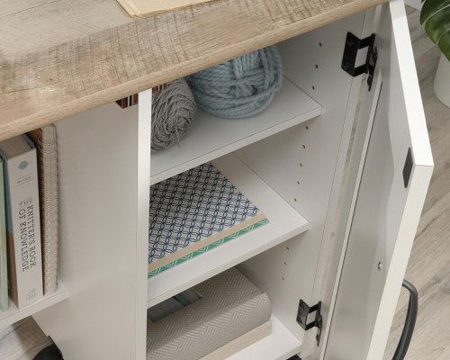 The Teknik Office Sewing / Craft Cart in a Soft White Finish with Lintel Oak accents is the delightfully simple office furniture offering ideal for any office or room in the house. The generous melamine work surface provides ample space for all of your crafting activities and is highly resistant to heat, stains and scratches, it also extends out and is supported by the main doors using easy roll castors for ease of movement and additional working space. The storage behind these main doors includes two storage bins and a discreet hidden shelf for your sewing machine. There are also two adjustable shelves behind the smaller door for even more storage for your hobby or activity. 