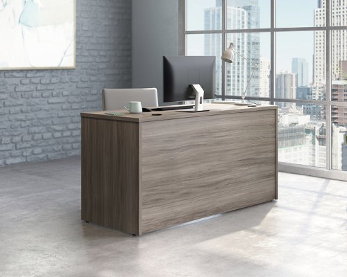 The Teknik Office Affiliate 1500 x 600 Desk is our functional and commercial style option for all manner of colour schemes and work spaces.  This desk offers a very durable 1” thick melamine heat, stain and scratch resistant top to hold up your laptop, favourite beverage and display items with ease. It comes with two handy grommet holes for easy cord management and the adjustable base feet will ensure it stays perfectly level on even the most uneven floors.  Beautifully finished in a Hudson Elm effect, this Desk also benefits from a 360 degree finish for adaptable placement within your office. It can be used as a stand alone desk or can be fastened to the left or right side of these Affiliate desking codes: to 5427413, 5427414 and 5427422 to extend your work area. There are also other matching cupboards, desks, hutches and bookcases within the Affiliate range which will complement this item.