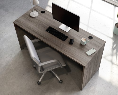 25773TK | The Teknik Office Affiliate 1500 x 600 Desk is our functional and commercial style option for all manner of colour schemes and work spaces.  This desk offers a very durable 1” thick melamine heat, stain and scratch resistant top to hold up your laptop, favourite beverage and display items with ease. It comes with two handy grommet holes for easy cord management and the adjustable base feet will ensure it stays perfectly level on even the most uneven floors.  Beautifully finished in a Hudson Elm effect, this Desk also benefits from a 360 degree finish for adaptable placement within your office. It can be used as a stand alone desk or can be fastened to the left or right side of these Affiliate desking codes: to 5427413, 5427414 and 5427422 to extend your work area. There are also other matching cupboards, desks, hutches and bookcases within the Affiliate range which will complement this item.