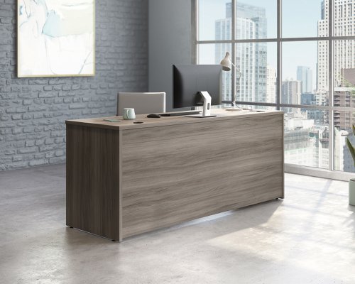 The Teknik Office Affiliate 1800 x 600 Desk is our functional and commercial style option for all manner of colour schemes and work spaces.  This large desk offers a very durable 1” thick melamine heat, stain and scratch resistant top to hold up your laptop, favourite beverage and display items with ease. It comes with two handy grommet holes for easy cord management and the adjustable base feet will ensure it stays perfectly level on even the most uneven floors.  Beautifully finished in a Hudson Elm effect, this Desk also benefits from a 360 degree finish for adaptable placement within your office. It can be used as a stand alone desk or can be fastened to the left or right side of these Affiliate desking codes: to 5427413, 5427427 and 5427468  to extend your work area. There are also other matching cupboards, desks, hutches and bookcases within the Affiliate range which will complement this item.