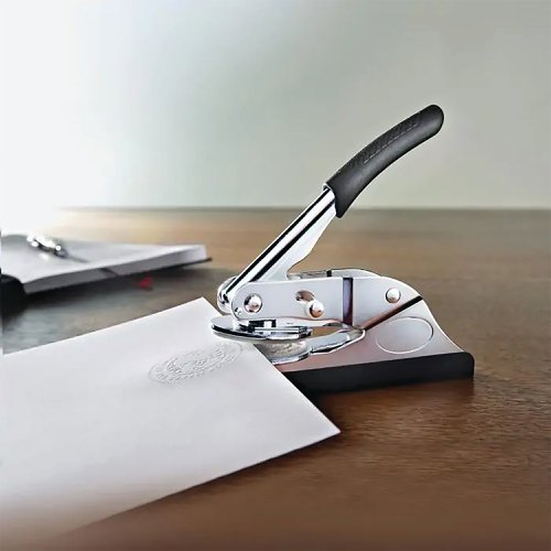 KF96750 | Q-Connect Custom Embossed Press Round. You can use it handheld, or insert it into the base to use as a desk press. Simply insert your shim up to 40mm in diameter, with space for a logo in the middle and a maximum 26 character motto or legend around the edge and press down to make your impression on paper up to 90gsm in weight. Upon ordering you will be sent a redeemable voucher. Complete the voucher with your text and/or graphics. Return the pre-addressed voucher and wait for your custom made-to-order embossed press.