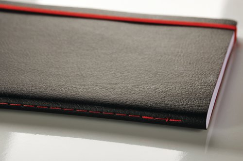 This premium Black n' Red A5 notebook contains 144 pages of quality Optik paper, which is ruled and numbered for neat, indexed notes. The casebound notebook features durable covers with a soft touch finish, as well as a red elasticated strap to help keep contents secure. The notebook also features an inside rear pocket for storage of additional loose pages. This pack contains 1 x A5 notebook.